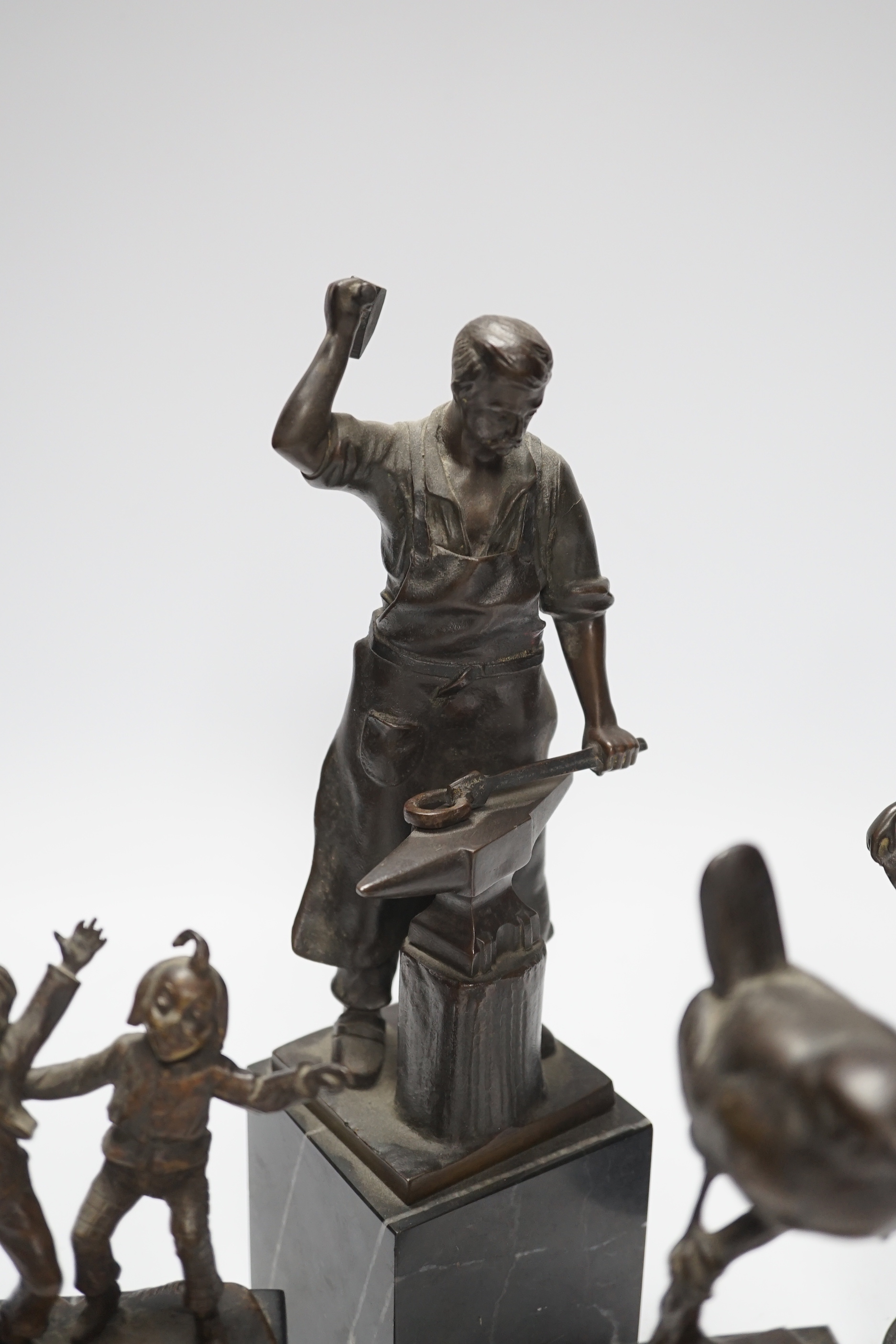 A German bronze of a blacksmith, indistinctly signed, a bronze figure group signed Öbold, a bronze of a Robin, signed K. Reynen and an unsigned bronze of a ballerina, all on marble bases, tallest 27cm (4)